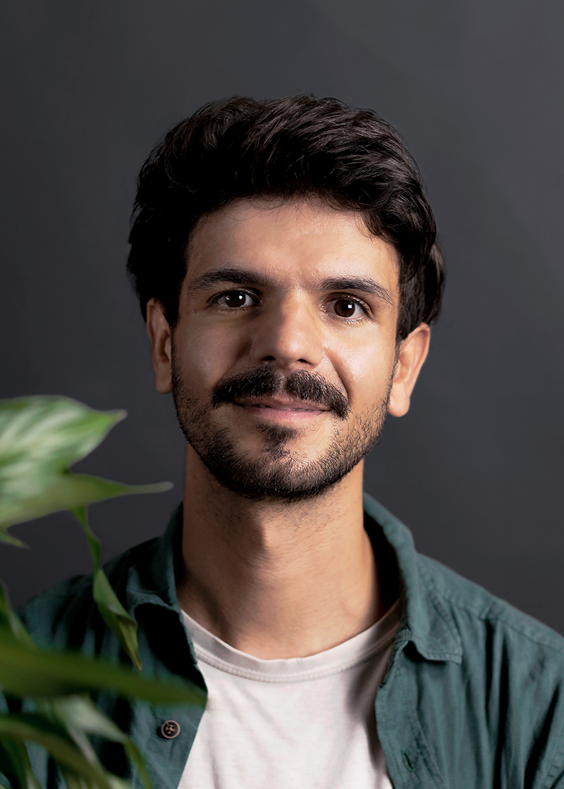 studio nunc team andreas lächelnd in einem grünen Hemd über einem hellen Shirt