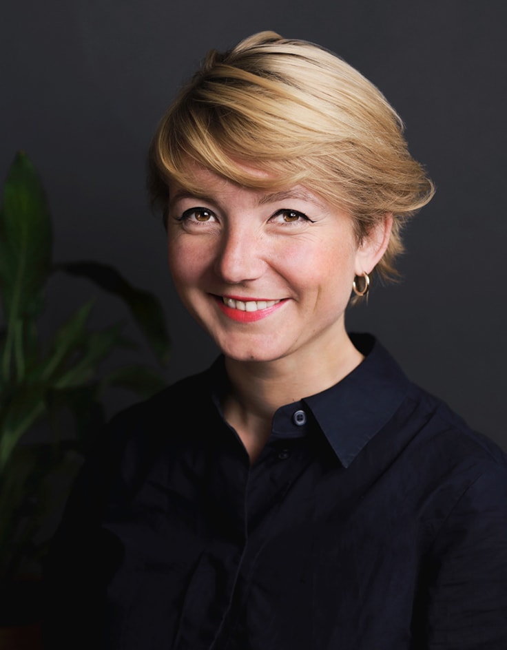 studio nunc team johanna lächelnd in einer dunkelblauen Bluse